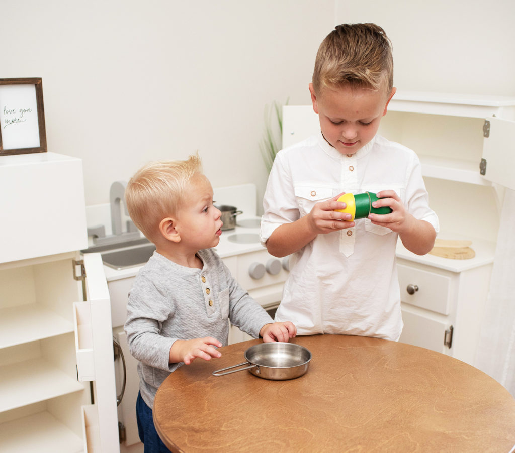 boys playing in wooden kitchen