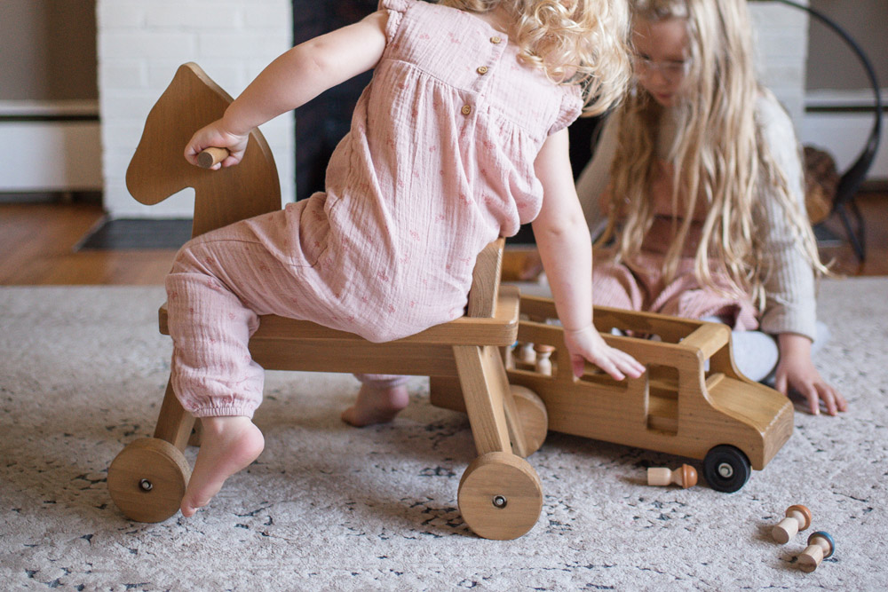 Girl Playing with Wooden Train Set