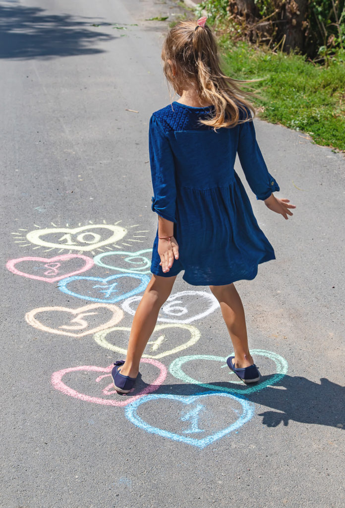 Child playing hopscotch outside